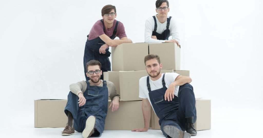 Four movers in Culver City posing with stacked cardboard boxes